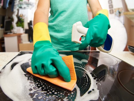 Professional cleaner carrying out routine house cleaning in a SE5 flat
